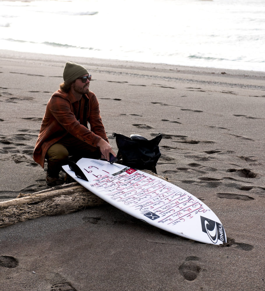 O'NEILL（オニール）チームメンバー TIMMY REYES（ティミー・レイズ） 砂浜でサーフボードと座っているところ